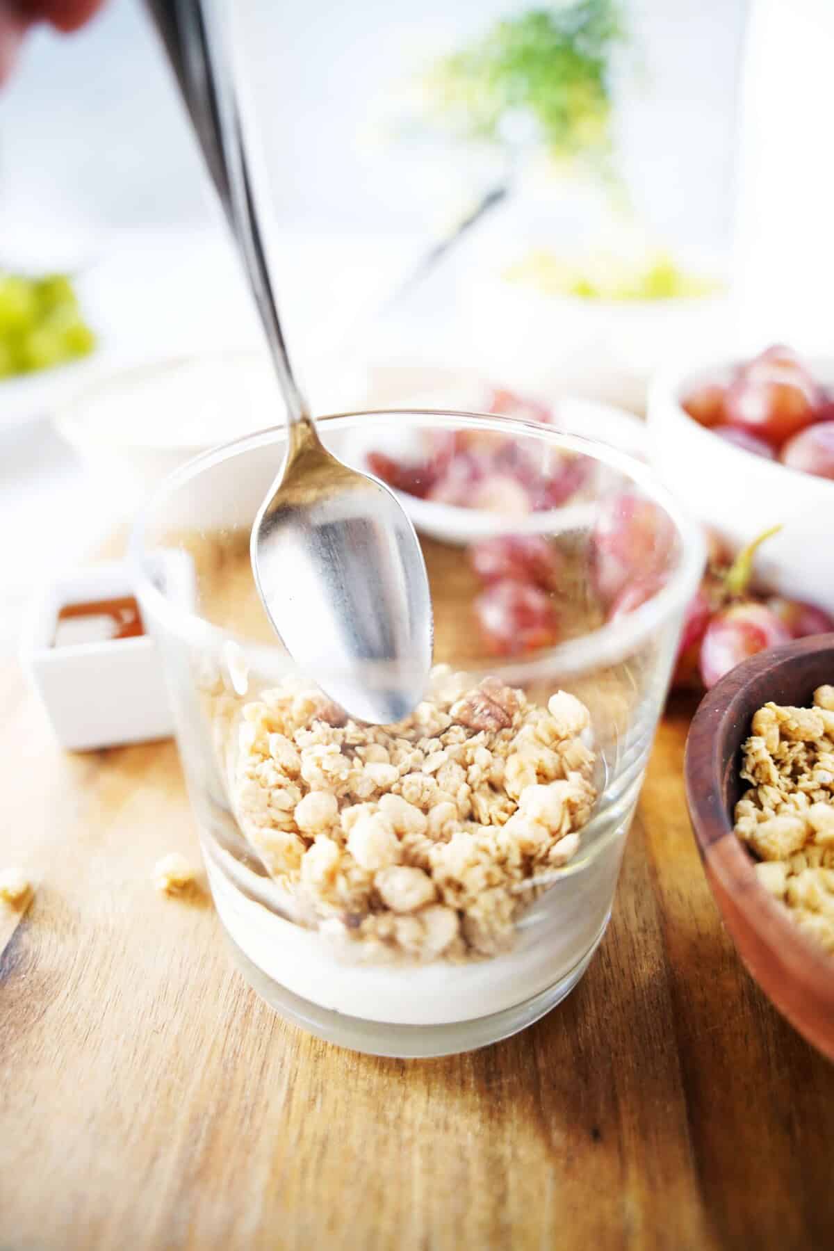 granola layer of parfait with spoon in parfait cup