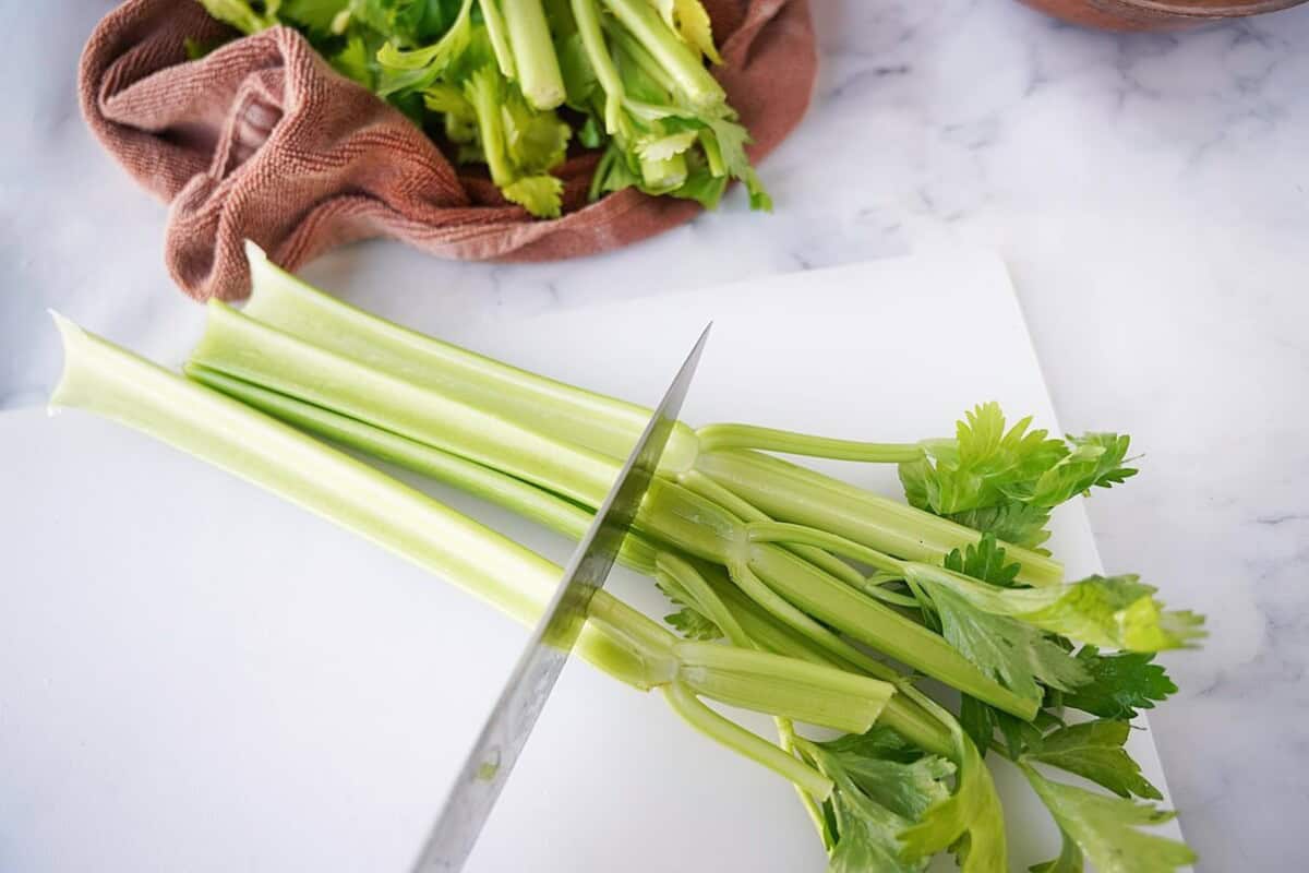 Trimming celery sticks on cutting board