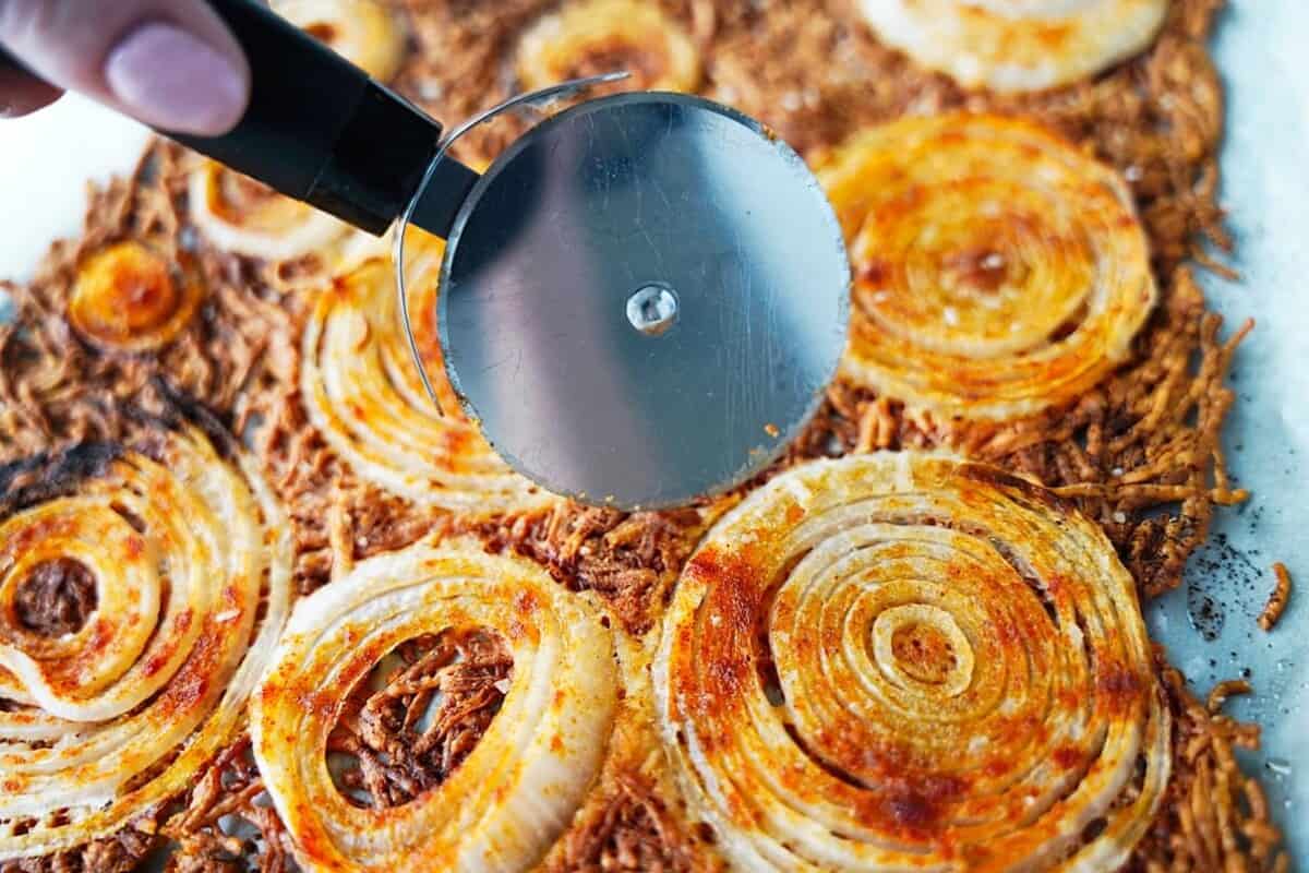 Cutting Crispy Onion Chips out of the oven with pizza cutter
