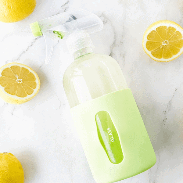 DIY Lemon Glass Cleaner surrounded by lemons on countertop