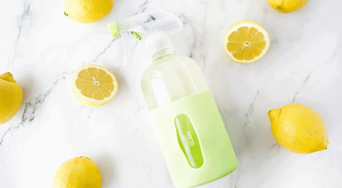 DIY Lemon Glass Cleaner surrounded by lemons on countertop