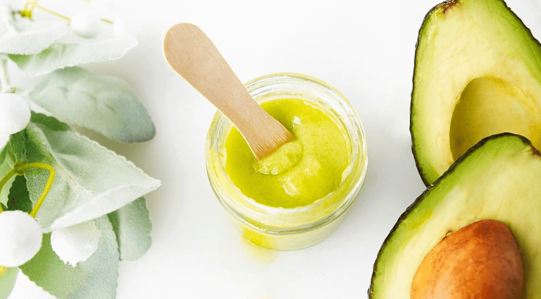 Homemade Avocado Face & Body Cream in container with flower and avocados