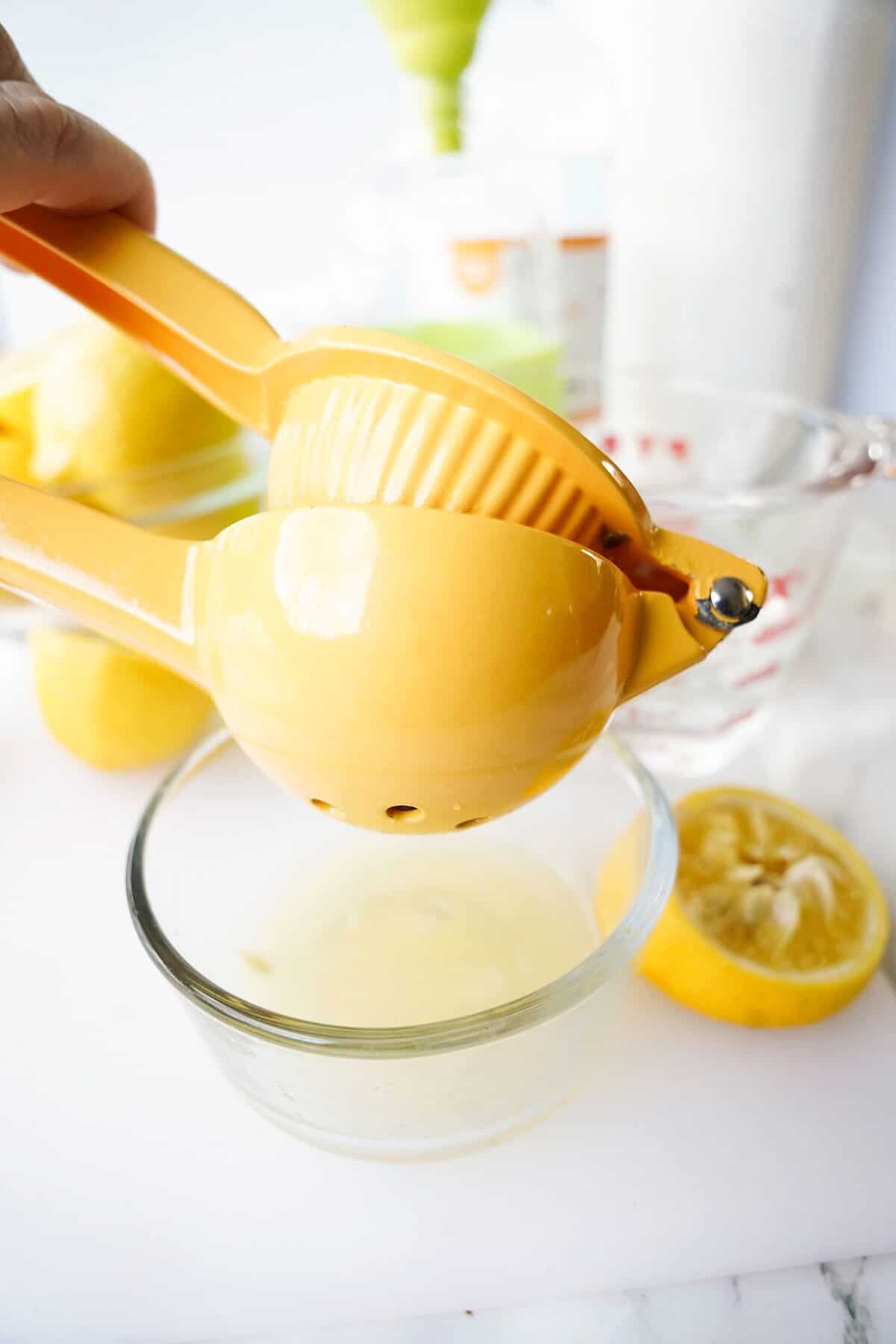 lemon juice being squeezed over small glass bowl