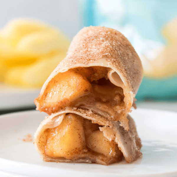 horizontal shot of cut open caramel apple egg roll on white plate