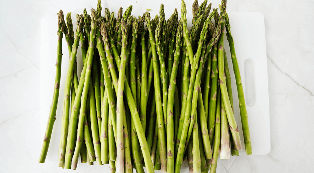 Whole Asparagus on White cutting board: How to Freeze Asparagus