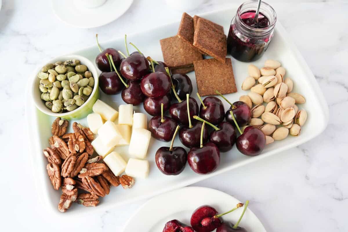 Cherries served with nuts, cheese, and crackers