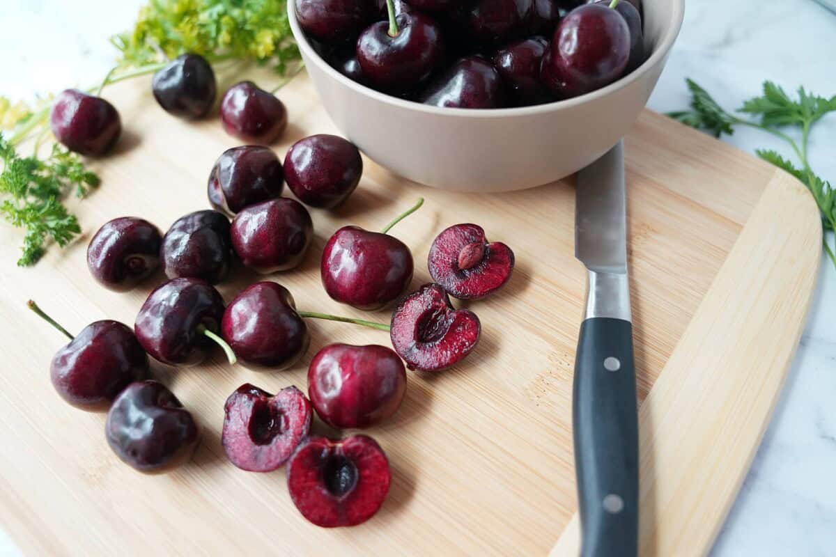 Halved cherries on a cutting board