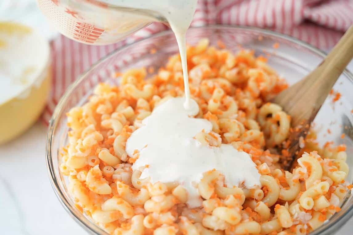 adding in the creamy dressing to make the Hawaaian Macaroni Salad