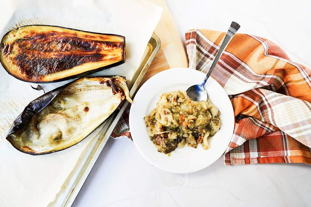 Mashing roasted eggplant with skins on sheet pan