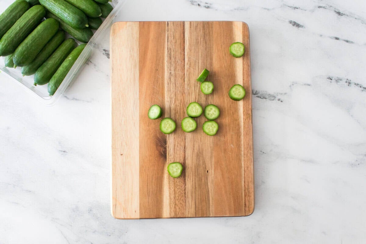 cutting board with baby cukes sliced