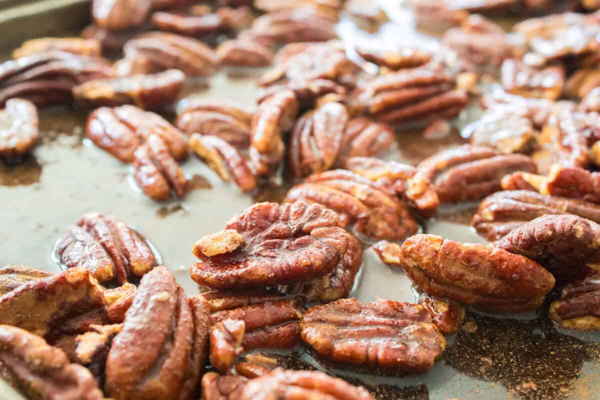 candied pecans after being tossed in maple syrup, cinnamon and vanilla before cooling