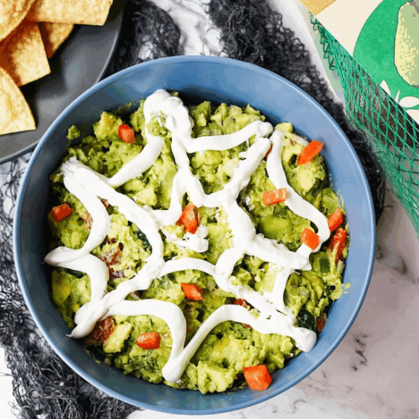 piderweb Guacamole in bowl with a bag of Westfalia Fruit avocados to the right
