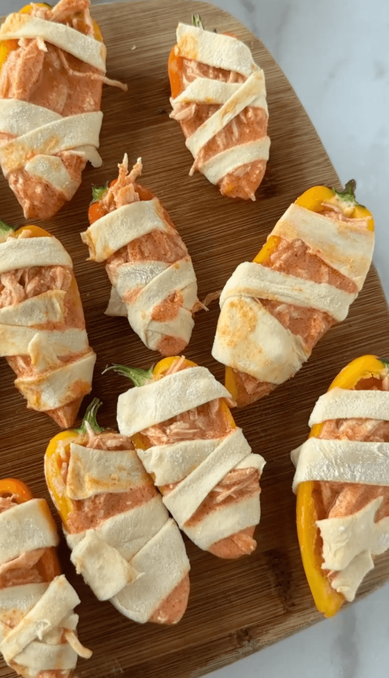 Board of wrapped bell pepprs into mummies before cooking