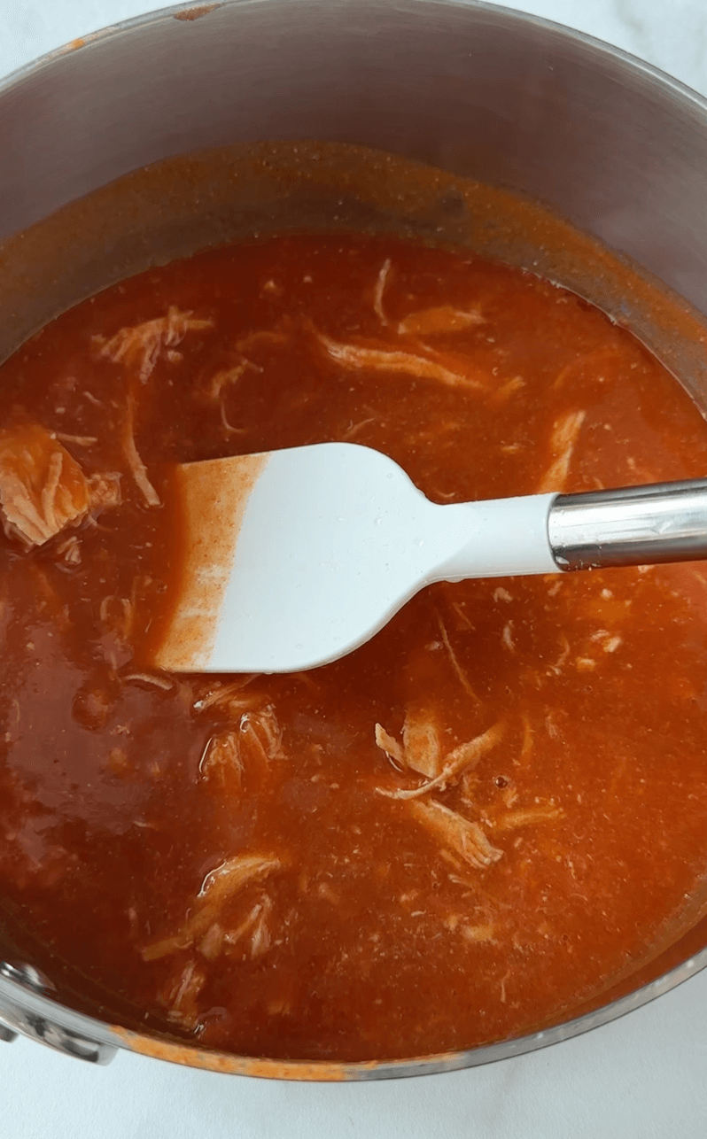 Pot with buffalo chicken mixture being stirred