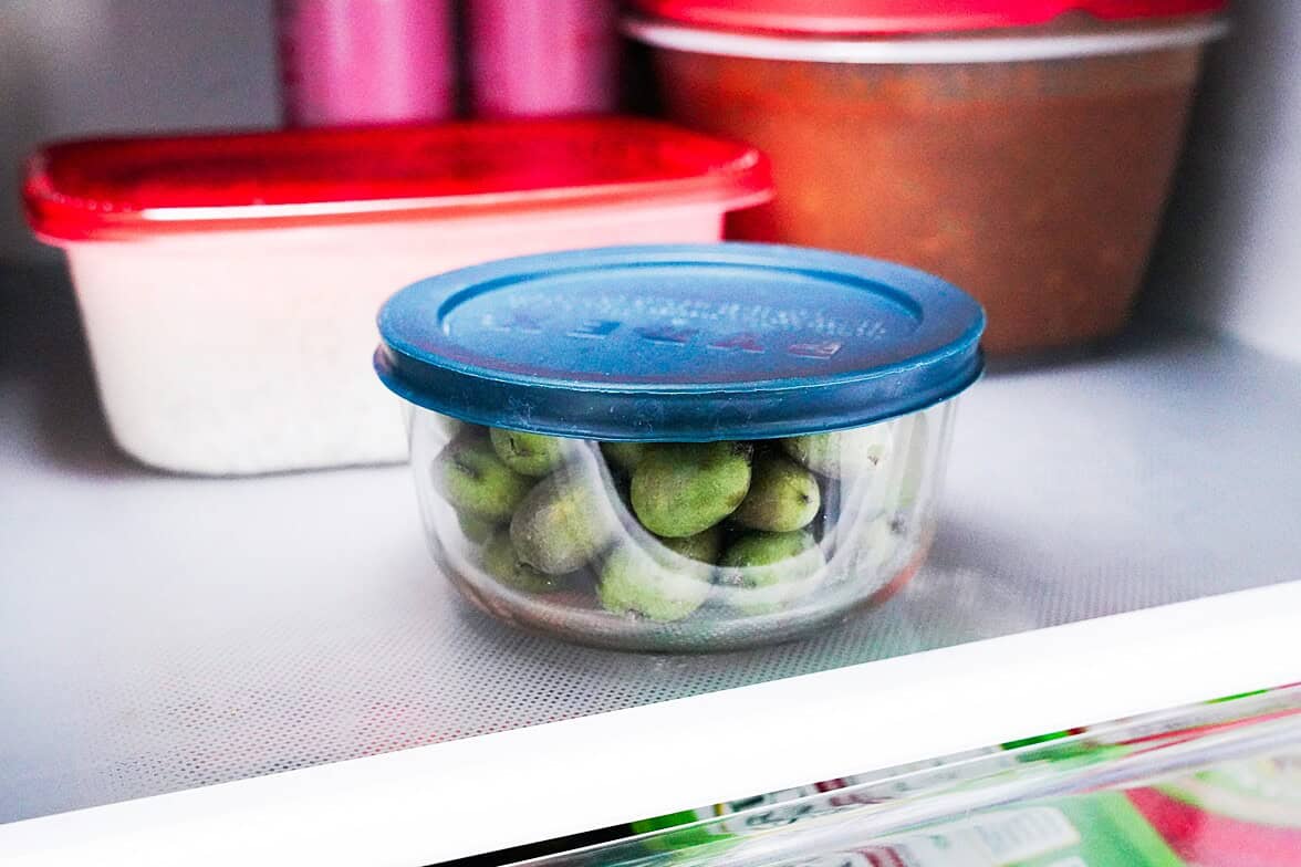 Kiwi berries in an airtight container on a fridge shelf