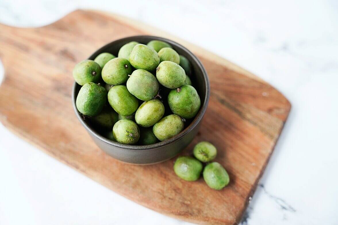 Kiwi Berries in a bowl on top of a cutting board