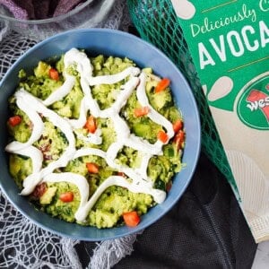 overhead shot of spiderweb guacamole with bag of Westfalia Fruit avocados with a