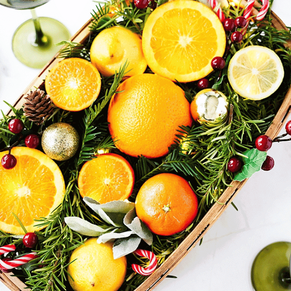 Citrus Centerpiece with Holiday decor of pine cones, cranberries, candy canes and mini oranmanets