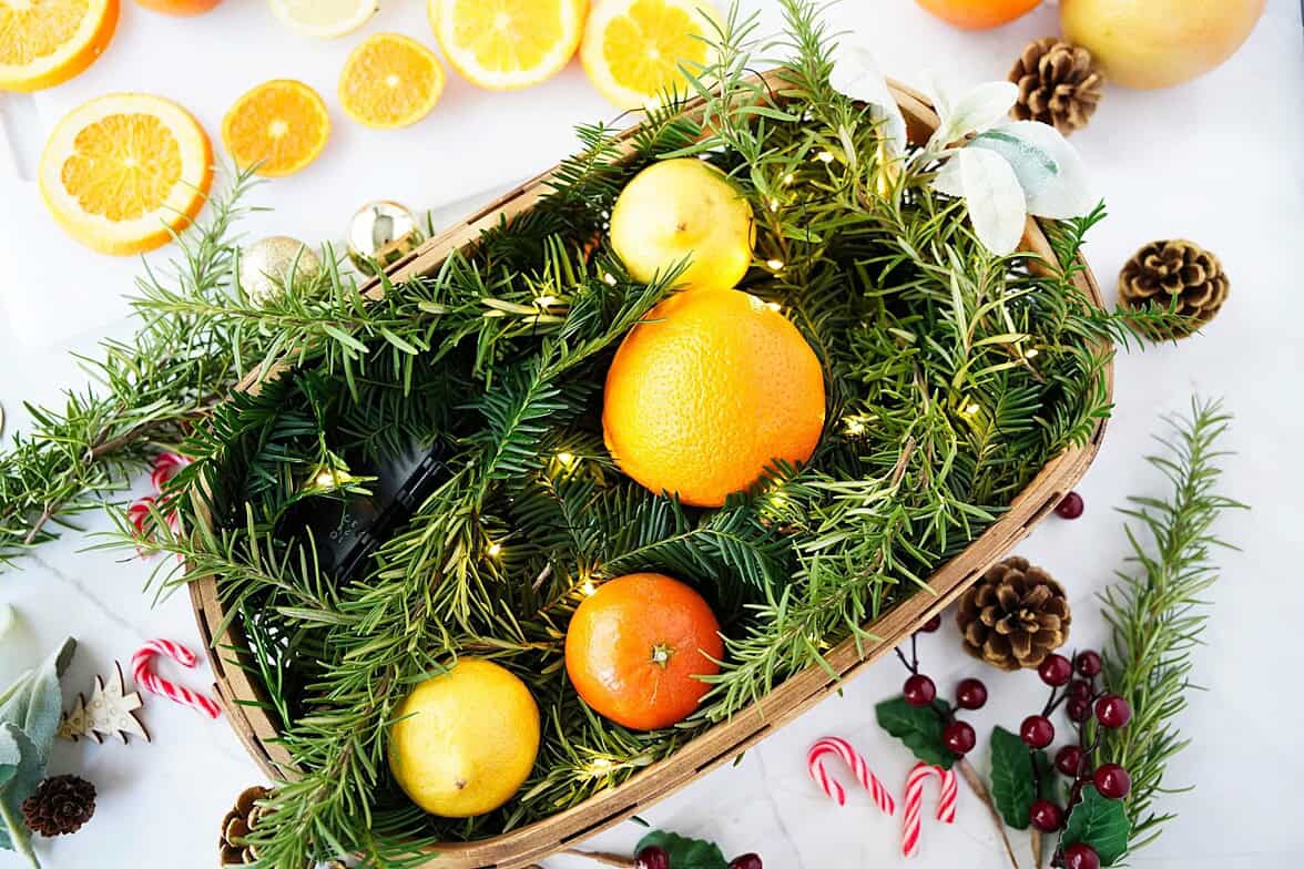 Adding citrus into basket currounded by Christmas decor