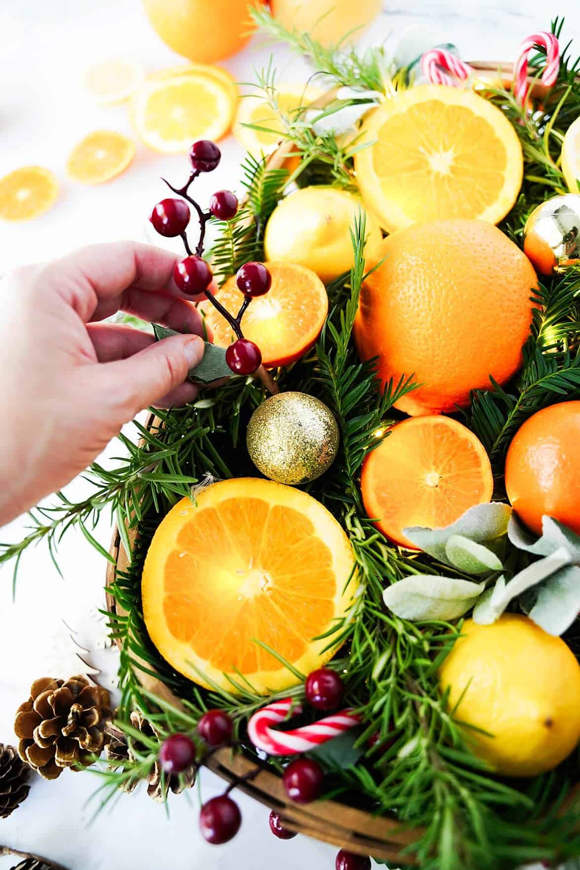 Adding finishing holiday touches to the Holidy Citrus Centerpiece