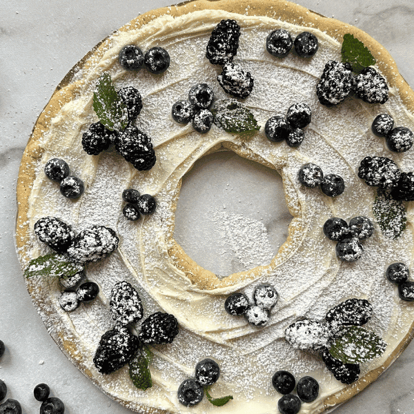 Overhead view of Berry Cookie wreath on countertop sourrounded by blueberries and blackberries
