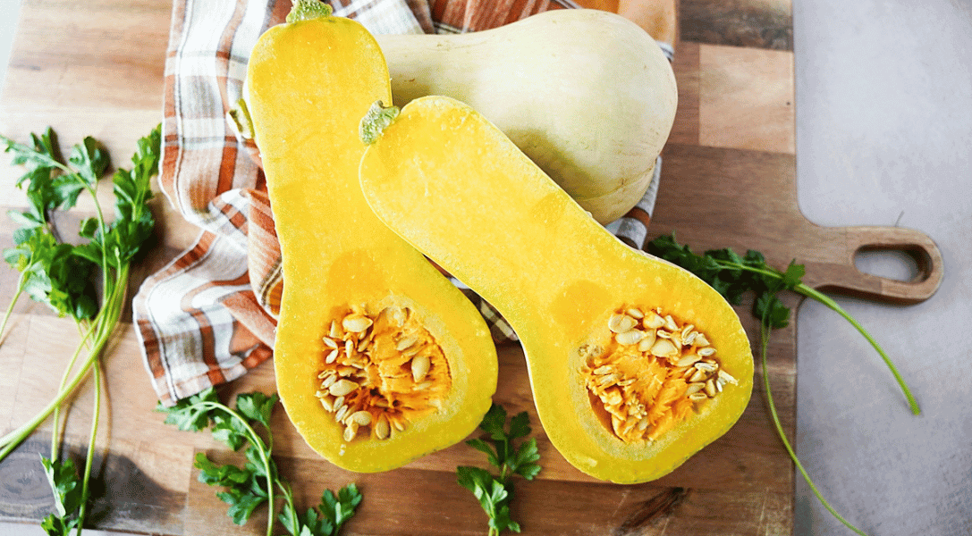 butternut squash cut in half on cutting board with flesh side up
