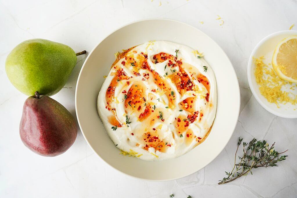 Hot Honey Whipped Ricotta Dip overhead with whole pears to the side of the bowl