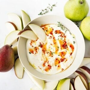 overhead view of finished Hot Honey Whipped Ricotta Dip with pear slices and whole pears surrounding bowl