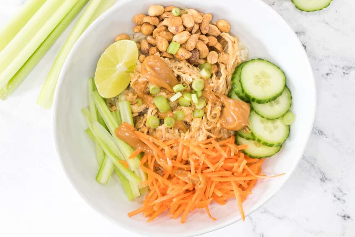 overhead shot of chicken and rice bowl with peanut sauce