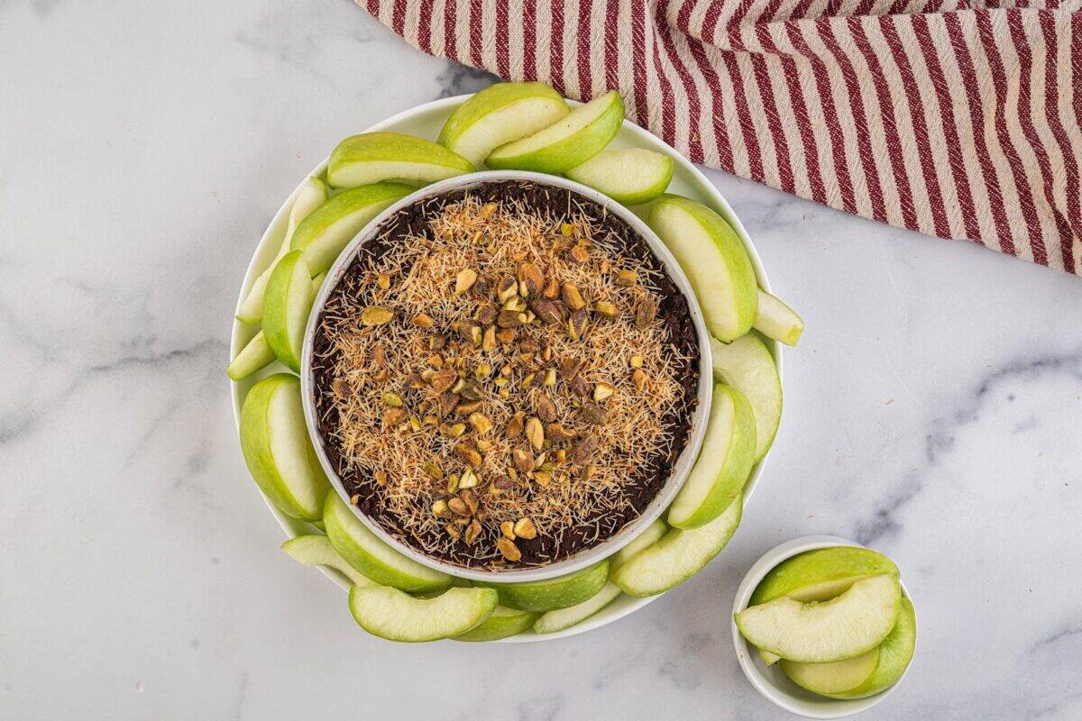 Dubai chocolate fruit dip with apples in a bowl