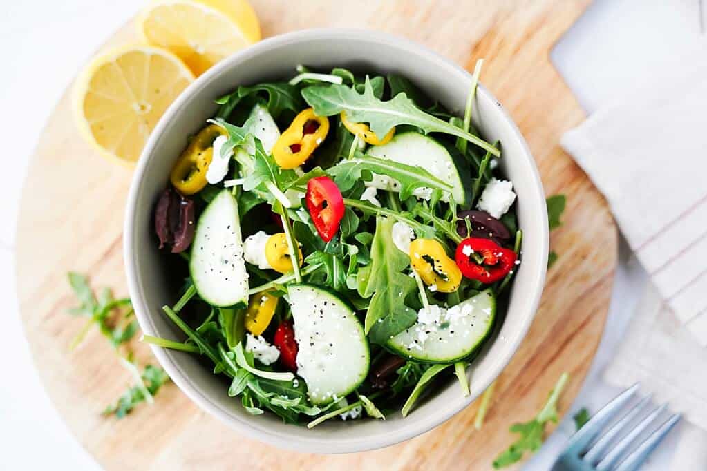 overhead view of arugla salad in white bowl