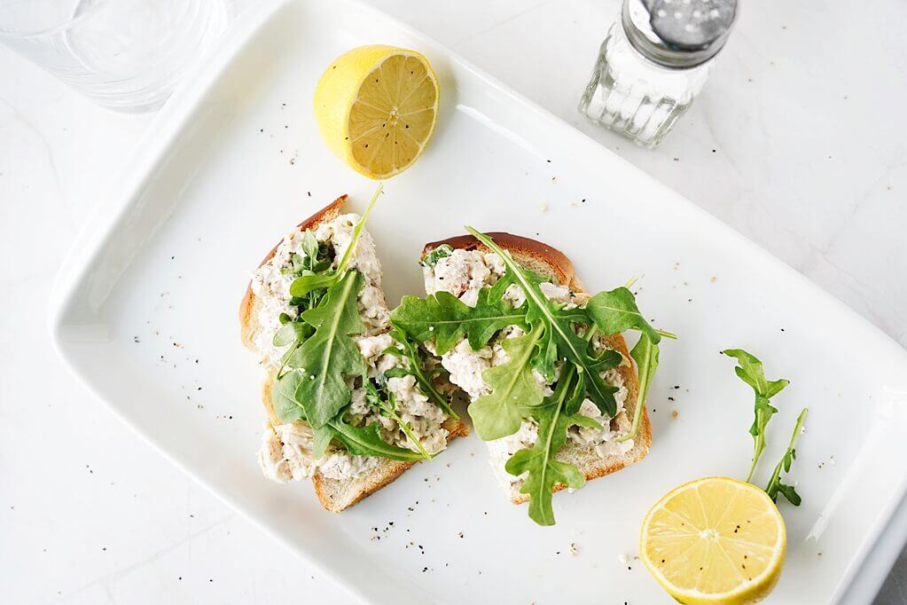 Arugula on an open-faced sandwich on a plate