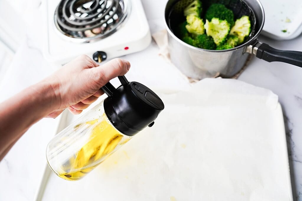 adding olive oil to parchmant-lined sheet pan