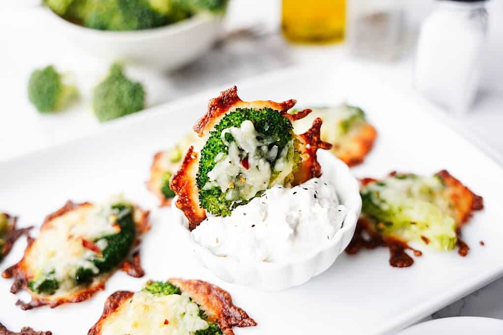 close up of smashed broccoli bite sitting in ranch dip