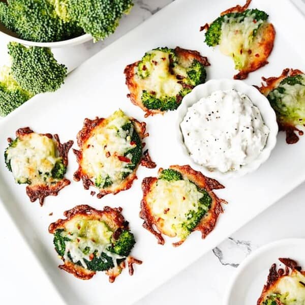 Overhead view of smashed broccoli bites on white plate