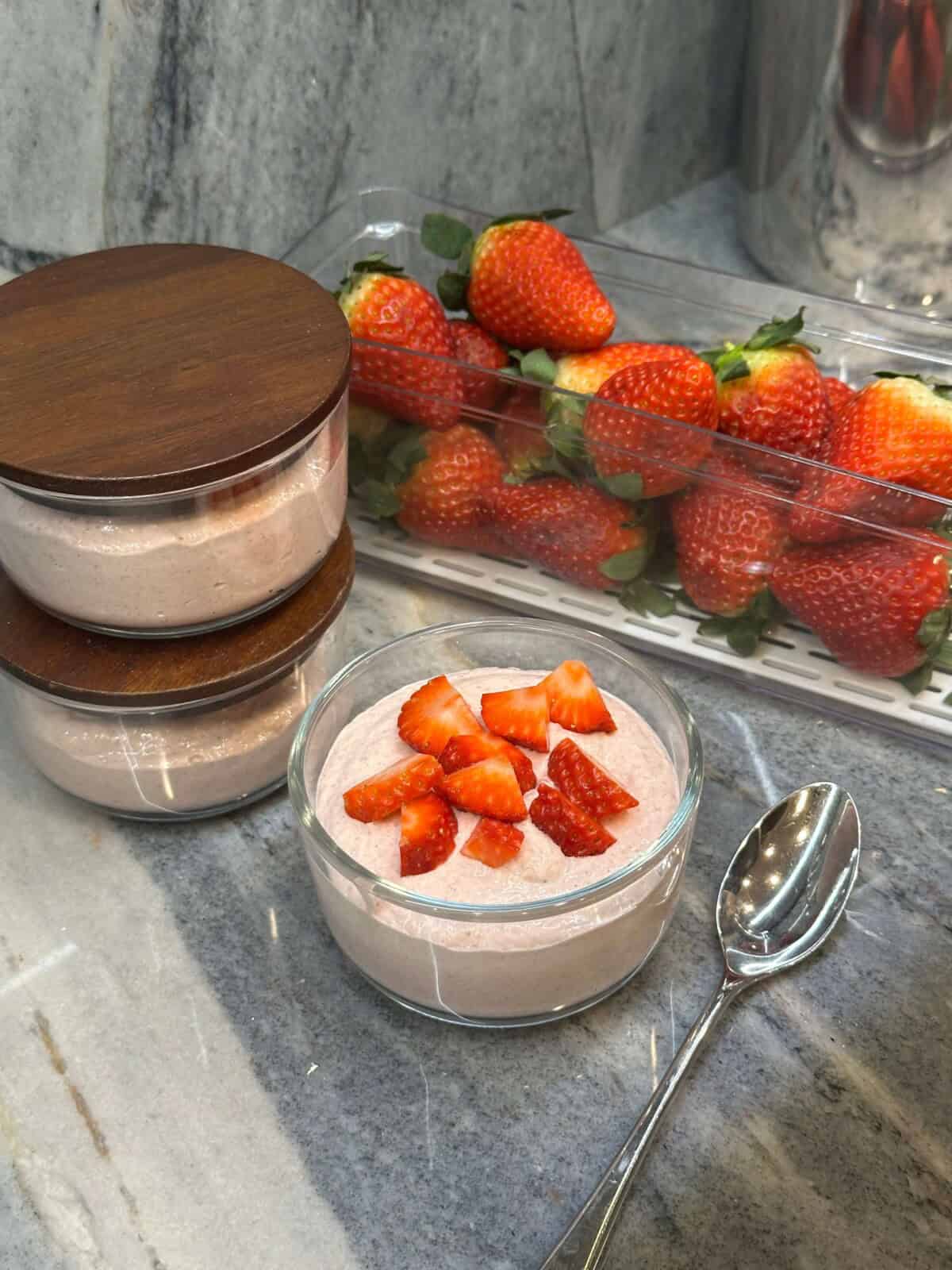 Blended Strawberry Overnight Oats in container with strawberries in background