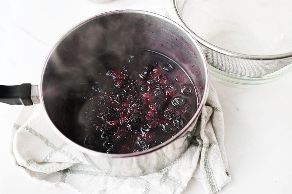 blueberries being cooked in pot
