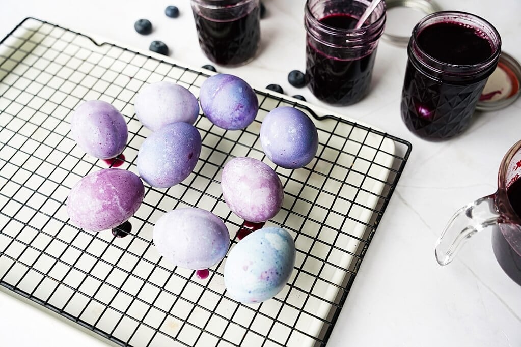 blueberry-dyed eggs on a cooling rack as they dry