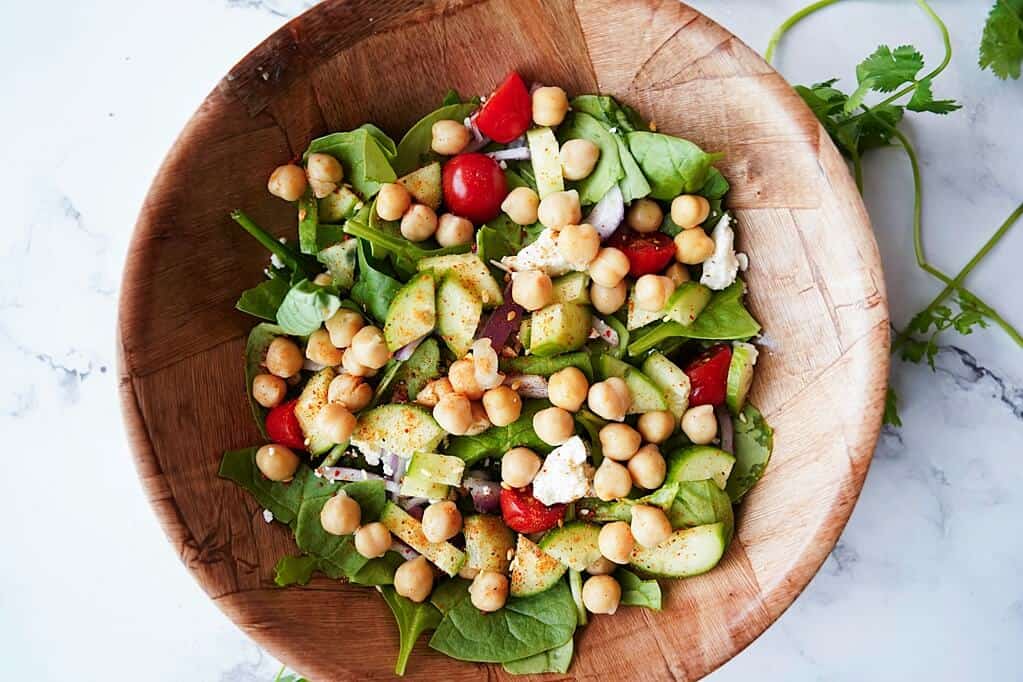 overhead view of salad with chickpeas in a wooden bowl