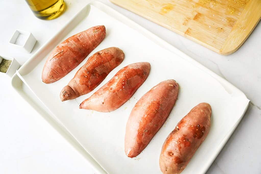 5 sweet potato halves on sheet pan facing down