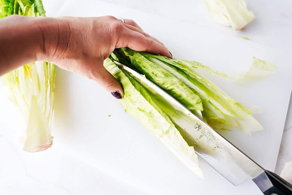 Step 3 in cutting romaine lettuce by vertically cutting