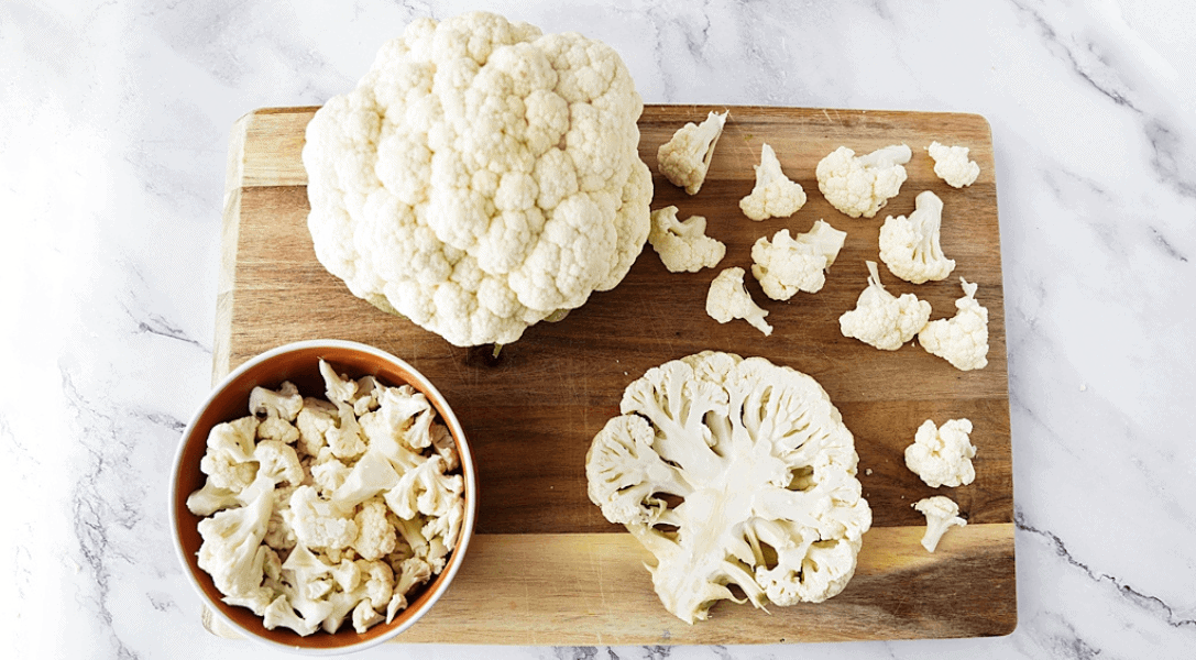 Head of cauliflower, cauliflower florets and cauliflower steak on wood cutting board