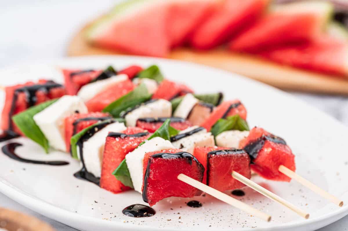 White plate with 3 Caprese Watermelon Skewers