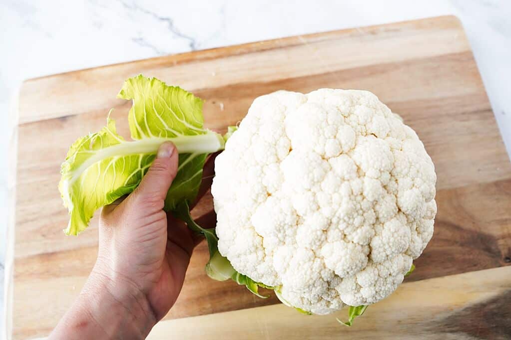 Taking off the green leaves of cauliflower