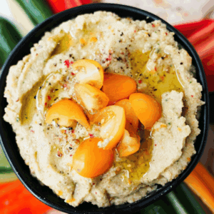 Overhead shot of Golden Tomato Hummus in a bowl on a snack plate