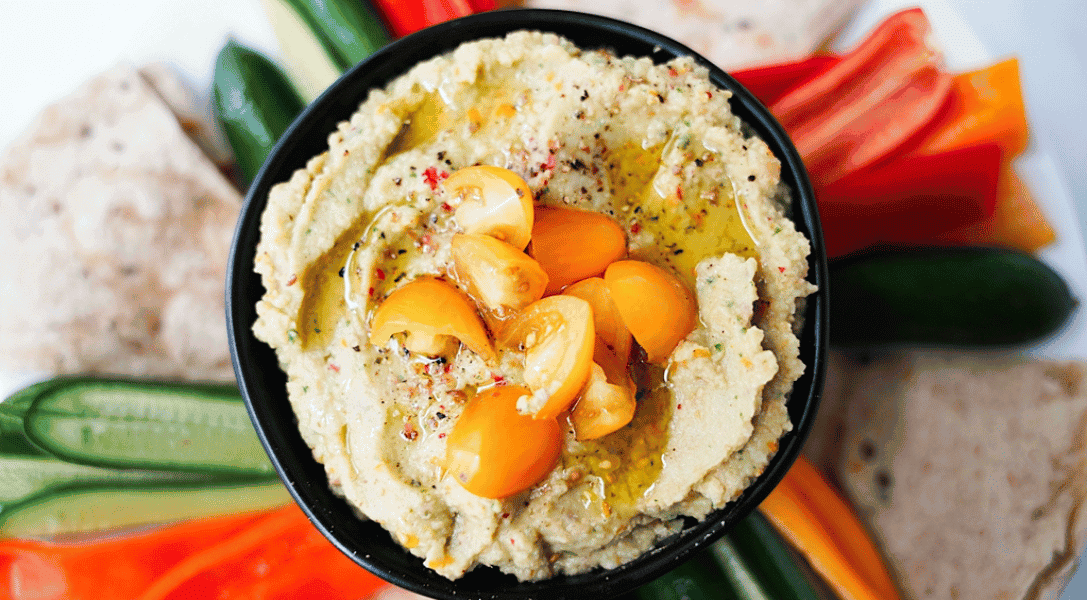Overhead shot of Golden Tomato Hummus in a bowl on a snack plate