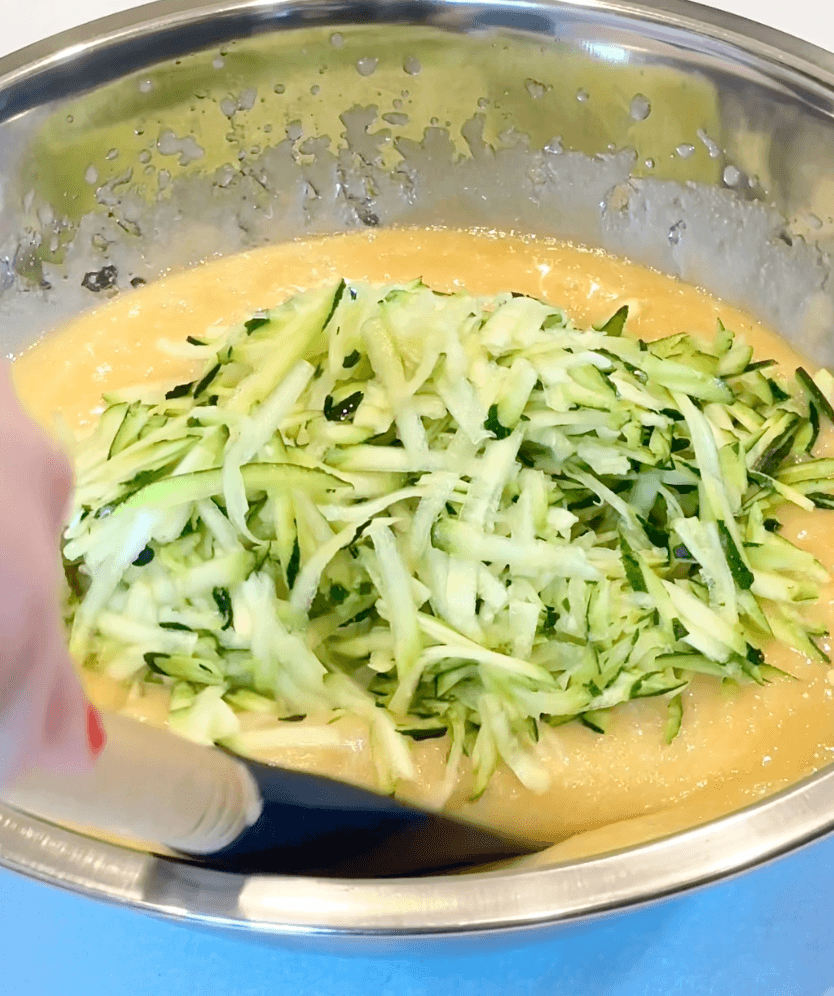 Shredded Zucchini being stirred into the bread dough batter