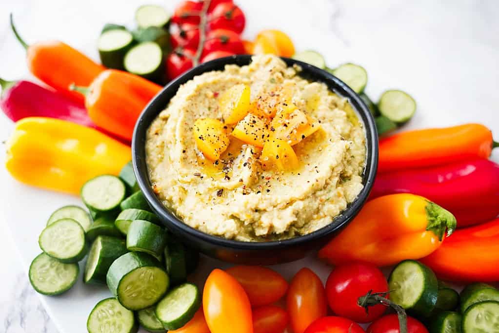 Fresh summer veggies cut and sliced and served with hummus