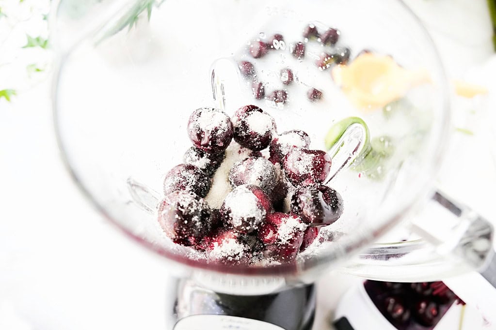 Fresh cherries and sugar in a blender