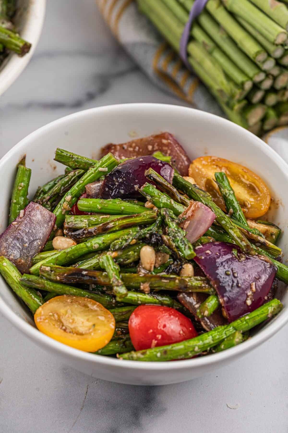 Grilled asparagus salad served in a white bowl